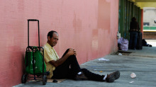 坐在人行道上胡安什么作为他等待洛杉矶汤厨房打开年9月13日,2011。弗朗西斯中心领取,是一个非营利的机构专门从事食品服务穷乏人,提供日常协助项目,提供物资和服务给低收入家庭,青年,无家可归。